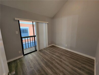 Spare room with vaulted ceiling, dark wood finish