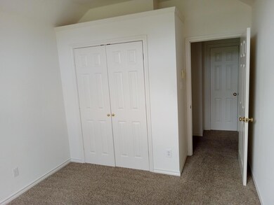 Unfurnished bedroom featuring a closet, dark colored carpet, and lofted ceiling
