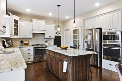 Rich wood tones throughout home give it a warm vibe.  Classic stainless-steel appliances and fresh light fixtures.