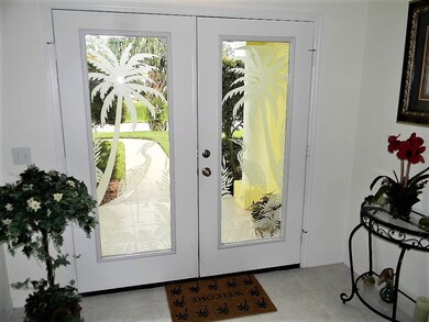 Double door entry is etched with tropical artwork.