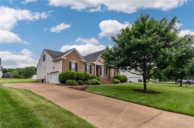 View of front of home featuring brick siding, driv