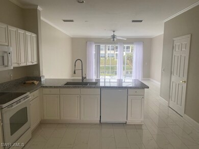 Kitchen featuring kitchen peninsula, white appliances, white cabinetry, and sink