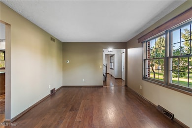 Unfurnished living room or office with dark wood finished floors and a textured ceiling