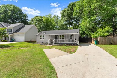 View of front of home featuring driveway, covered porch, and an attached garage