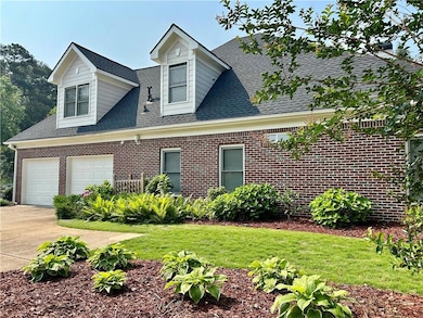 View of front of house with concrete driveway, roof with shingles, brick siding, and a front lawn
