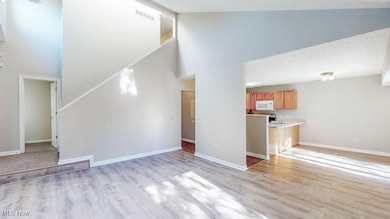 Living room with high vaulted ceiling and light wood-style floors