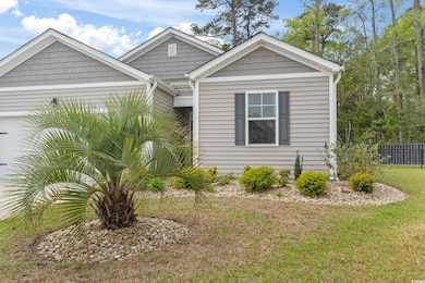View of front facade with fence, an attached garage, and a front lawn