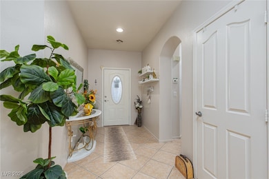 Entrance foyer featuring arched walkways, light ti