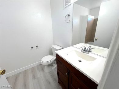 Full bath featuring vanity, toilet, and baseboards