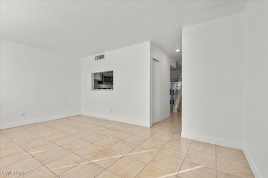 Unfurnished room featuring light tile patterned flooring and baseboards