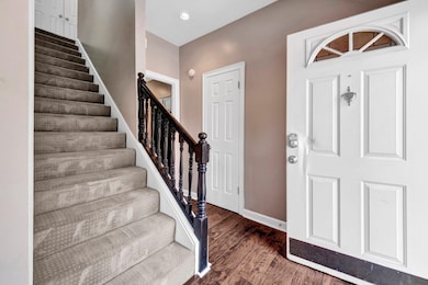 Foyer featuring wood finished floors, stairs, and recessed lighting