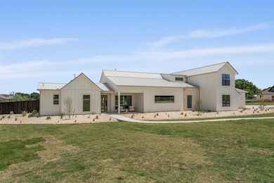 Back of property featuring metal roof, a standing