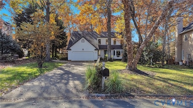 Traditional-style house featuring a front lawn, concrete driveway, and a garage