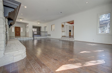 Unfurnished living room with wood-type flooring, crown molding, and recessed lighting