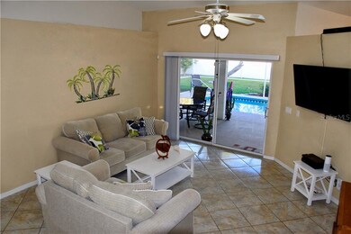 Living room with cathedral ceilings and sliders to screened pool/lanai