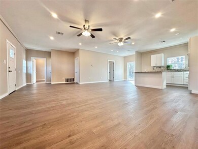 Unfurnished living room featuring ceiling fan, sin