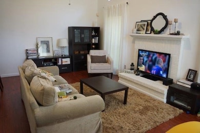 Living area featuring wood finished floors and a brick fireplace