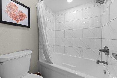 Bathroom with toilet and shower / bathtub combination with curtain