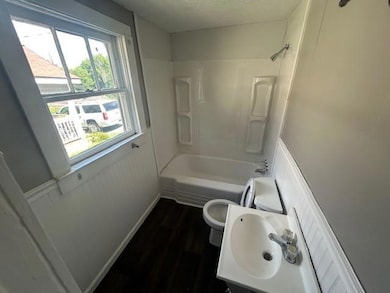 Bathroom featuring wood finished floors, plenty of natural light, shower / bathtub combination, and vanity