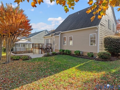 Beautifully landscaped backyard with raised deck and expansive stamped-concrete patio—ideal for relaxing or entertaining in a private outdoor setting.