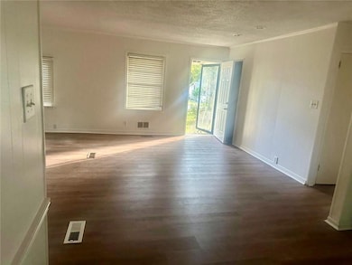 Unfurnished room with ornamental molding, dark wood-type flooring, and a textured ceiling
