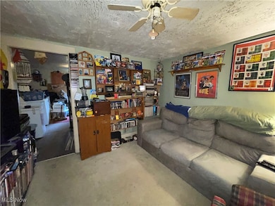 Living area with a textured ceiling and ceiling fan