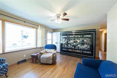 Living room with wood-type flooring and ceiling fan