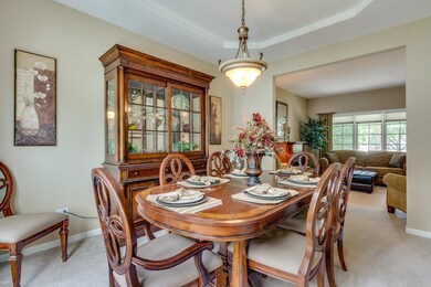 Dining room has tray ceiling and flows well into t