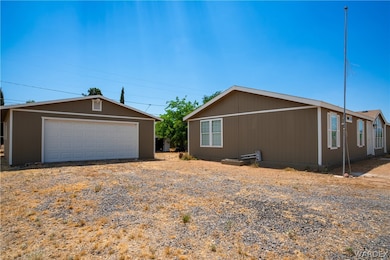 View of front of house with a garage and an outbui