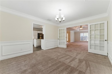 Spare room featuring french doors, a wainscoted wa