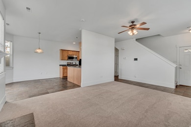 Unfurnished living room with dark colored carpet, a ceiling fan, stone finish flooring, and recessed lighting