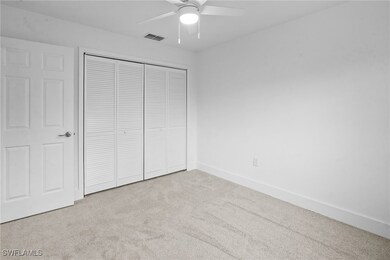Unfurnished bedroom with light carpet, a ceiling fan, and a closet