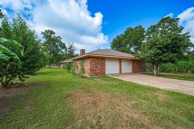 Charming brick home with a two-car garage set on a spacious, lush green lot. The property is surrounded by mature trees, offering privacy and a serene atmosphere. Ideal for those seeking a peaceful retreat with ample outdoor space.