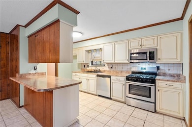 Kitchen featuring sink, cream cabinetry, light til