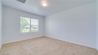 Carpeted empty room with baseboards and a smoke de