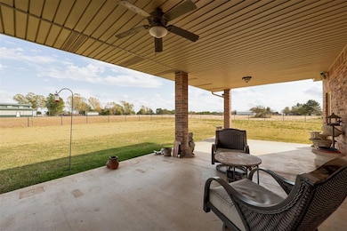 View of patio with ceiling fan and fence