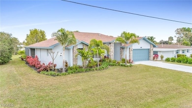 Ranch-style house with stone siding, a front yard, concrete driveway, and stucco siding