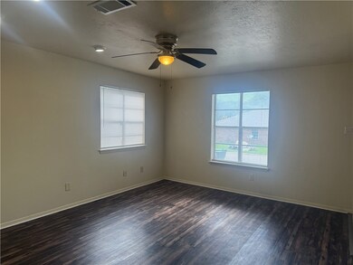 Spare room featuring dark wood finished floors, ce