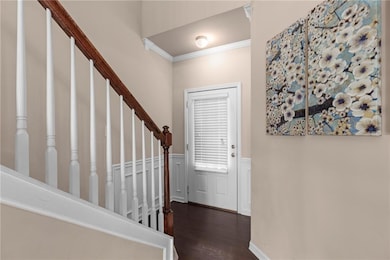Foyer featuring crown molding, wood finished floor