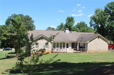 Back of house with brick siding and a chimney