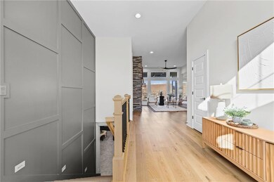 Hall with light wood finished floors and recessed lighting