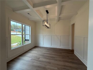 Unfurnished dining area featuring a decorative wall, coffered ceiling, a chandelier, beamed ceiling, and dark wood-style floors