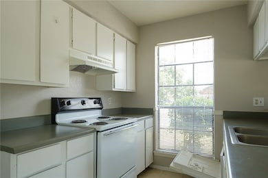 Kitchen featuring under cabinet range hood, white