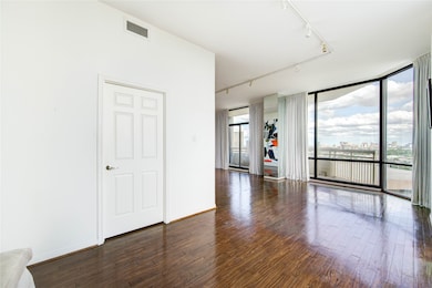 Another view of the open living space reveals expansive windows that fill the room with natural light, enhancing its warm, airy feel.