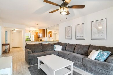 Living room featuring light wood-style flooring, a ceiling fan, and a chandelier