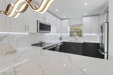 Kitchen featuring a sink, white cabinetry, light s