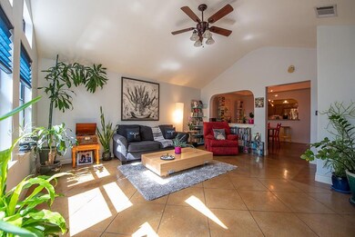 Tiled living room with ceiling fan, arched walkwa