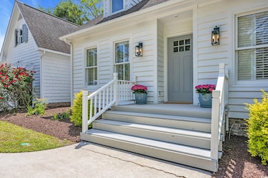 Doorway to property featuring a shingled roof