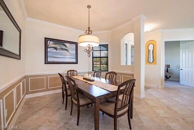 Dining space with ornamental molding, wainscoting, and a decorative wall