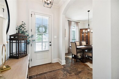 FOYER WITH ARCHES GOING INTO FORMAL DINING